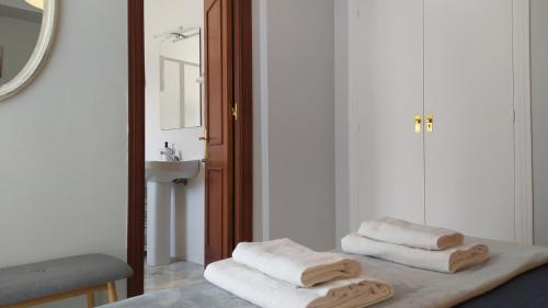 two towels are sitting on a table in a bathroom at Sherryflat Claveles - Parking in Jerez de la Frontera