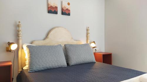 a bedroom with a bed with two pillows on it at Sherryflat Claveles - Parking in Jerez de la Frontera