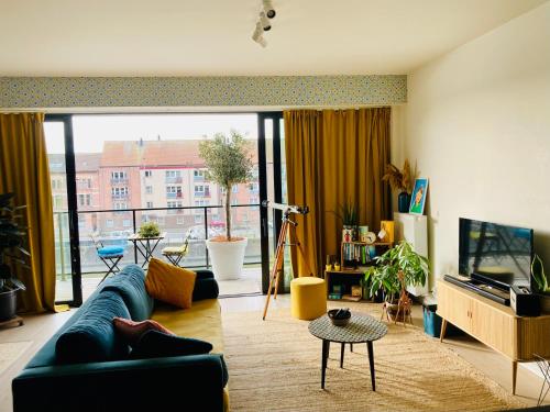 un soggiorno con divano blu e una grande finestra di Cozy two bedroom Apartment near city centre Gent a Gand