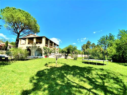 a large yard with a house in the background at Gîte et chambre d'hôtes LE MERCOIRE, piscine chauffée et jacuzzi in Aubenas