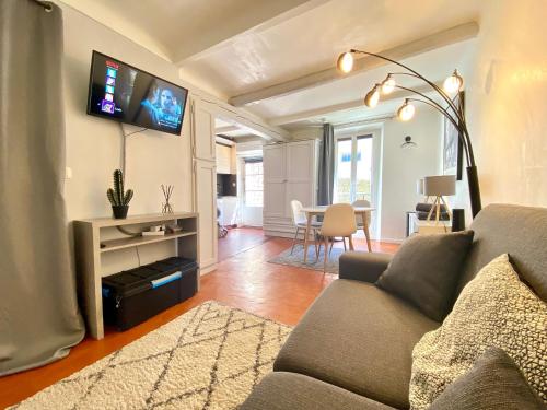 salon z kanapą i telewizorem na ścianie w obiekcie La Castre By SCLS Locations w Cannes