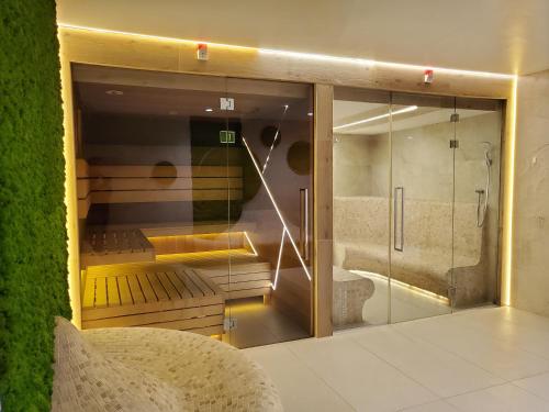 a room with a bathroom with a shower and a glass wall at Antonińska Resort SPA in Boszkowo