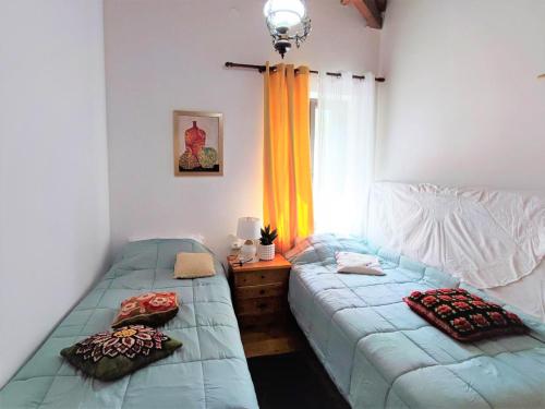 2 camas individuais num quarto com uma janela em Archontiko Kastellia em Evangelístria