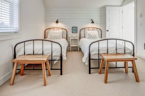 2 Einzelbetten in einem Zimmer mit 2 Tischen in der Unterkunft Beach Vibes in Lincoln City