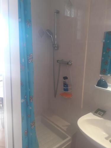 ein Bad mit einer Dusche und einem Waschbecken in der Unterkunft Studio Neptune in Arromanches-les-Bains