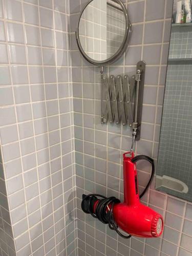 a red umbrella hanging on a wall in a shower at Fregene's Studio Monolocale in Fregene