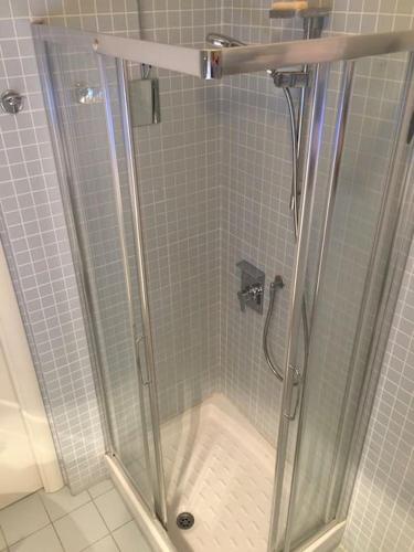 a shower with a glass door in a bathroom at Fregene's Studio Monolocale in Fregene