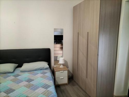 1 dormitorio con 1 cama y armario de madera en Affittibreviferrera monolocale Ferrera 20 minuti da RHO Fiera, en Bareggio