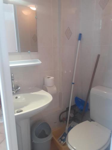 Un baño con inodoro, lavabo y espejo. en Studio Neptune, en Arromanches-les-Bains