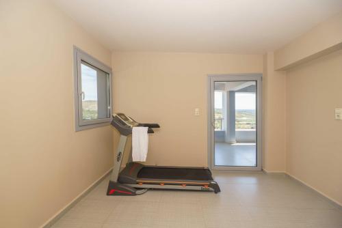 an empty room with a treadmill and a window at Villa Capparis in Moírai