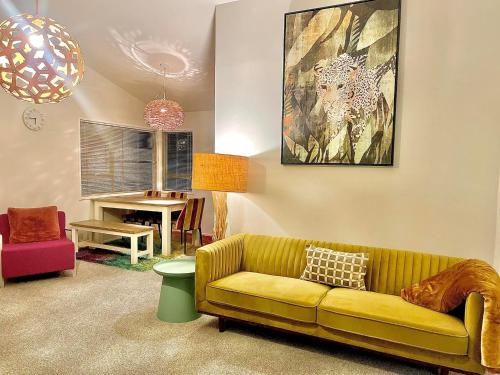 un soggiorno con divano giallo e tavolo di Aucktons house ad Auckland