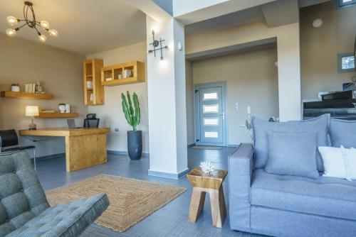 a living room with two blue chairs and a table at Villa Capparis in Moírai