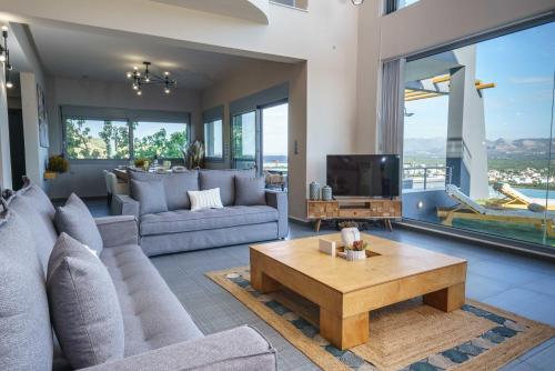 a living room with a couch and a tv at Villa Capparis in Moírai