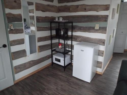 a refrigerator in a room with wooden walls at Bed and Breakfast Comfy & Cozy in Huntsville