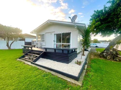 a small white house with a picnic table in a yard at Aucktons house in Auckland