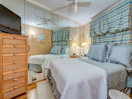 een slaapkamer met 2 bedden, een dressoir en een spiegel bij Seaside Villa 332, 1 Bedroom, Pool, Oceanside, 3rd Floor, Wi-Fi, Sleeps 4 in Hilton Head Island