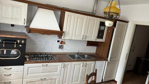 eine Küche mit weißen Schränken und einem Waschbecken in der Unterkunft La casa della Nonna in Figline Valdarno