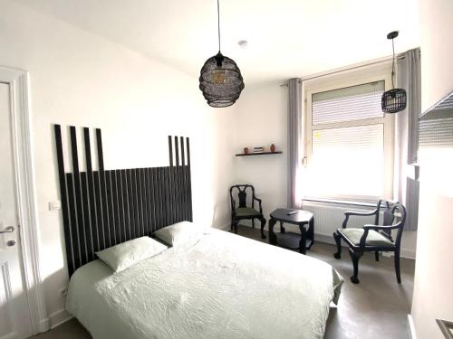 ナミュールにあるAu logement mosanのベッドルーム1室(ベッド1台、椅子2脚、窓付)