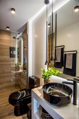 ein Bad mit einem schwarzen Waschbecken und einer Dusche in der Unterkunft A & B Minimal Suite ΙΙ with Sea View in Argostoli in Argostoli
