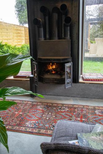 a fireplace in a living room with a rug in front at Tailors Trail Beaufort Holiday Home and Rooms in Mullerthal in Beaufort