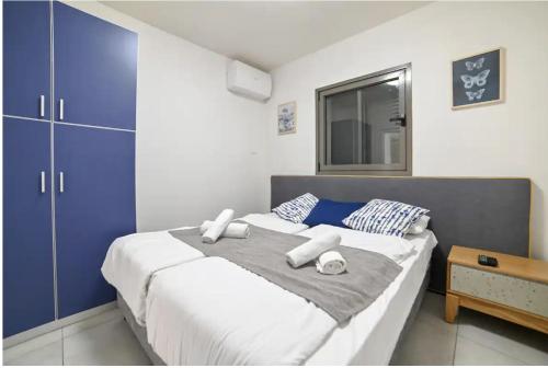 a bedroom with a large bed with blue cabinets at Magdala Infront Sea of Galilee and Mount Harbel in Migdal
