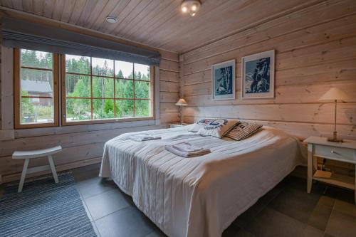 ein Schlafzimmer mit einem großen Bett in einem Blockhaus in der Unterkunft Aava Koli in Kolinkylä