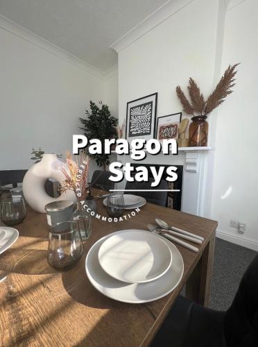 a dining room table with white plates on it at Templar House - Sleeps 6, Special Weekly Monthly Stay Rates, Central Location with FREE Parking, FREE WiFi, Perfect for ALTON TOWERS & M6 in Stoke on Trent