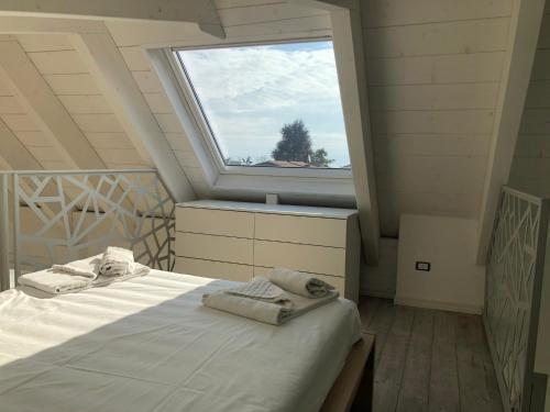 Un dormitorio con una cama y una ventana grande. en Attico 24, Residence Gardalido, en Padenghe sul Garda