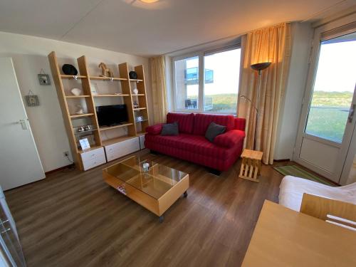 a living room with a red couch and a coffee table at Terminated in Cadzand