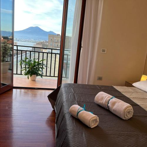 a bedroom with two pillows on a bed with a balcony at Vip sul mare in Castellammare di Stabia