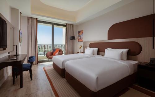 a hotel room with two beds and a desk at Savitsky Plaza in Samarkand