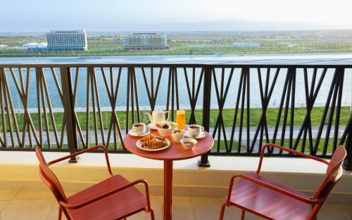 een tafel met 2 stoelen en een bord eten op een balkon bij Savitsky Plaza in Samarkand