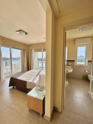 a large bedroom with a bed and a bathroom at Hotel Adria in Milano Marittima