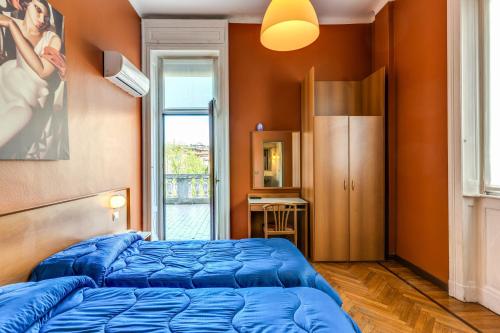 a bedroom with a blue bed and a window at Hotel Apollo in Milan