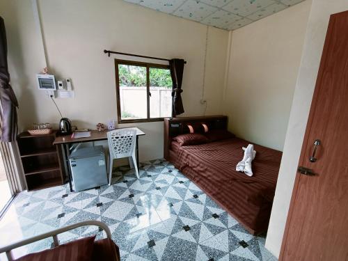 a bedroom with a bed and a desk and a window at Win Gray Homestay Resort in Pathiu
