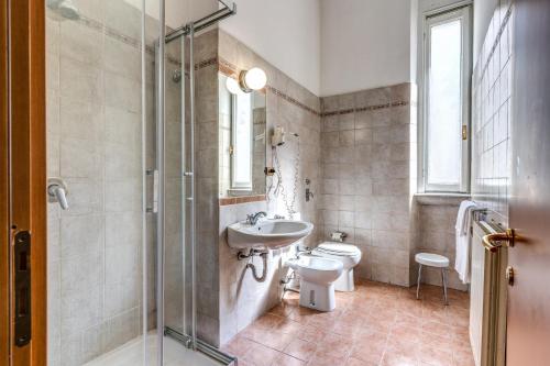y baño con aseo, lavabo y ducha. en Hotel Apollo en Milán