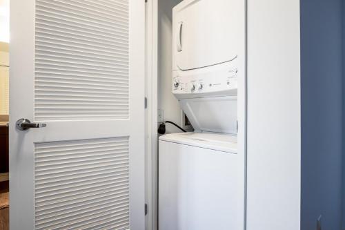 a bathroom with a washer and dryer next to a door at SoMa 2BR Gym Roofdeck nr Muni Whole Foods SFO-296 in San Francisco