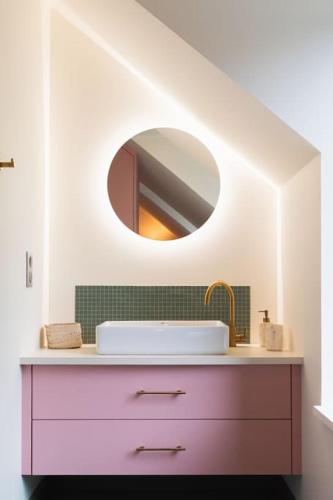 une salle de bain avec un lavabo et un miroir dans l'établissement Magnifique ferme rénovée, à La Landec