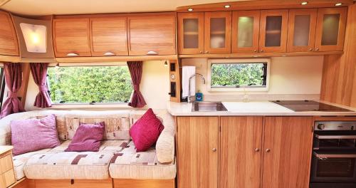 una sala de estar con sofá en una caravana en Park Farm Holidays Glamping en Lyndhurst