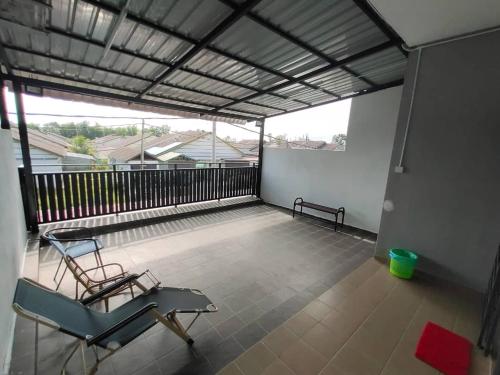 a balcony with a chair and a bench on it at cs homestay in Kuantan