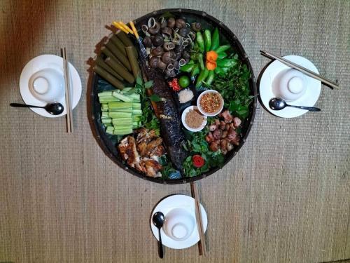 une table avec une plaque de nourriture sur une table dans l'établissement Sweet Mai Châu Homestay, à Hòa Bình