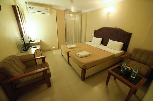 a hotel room with a bed and two chairs at HOTEL UDUPI INTERNATIONAL in Nāgercoil