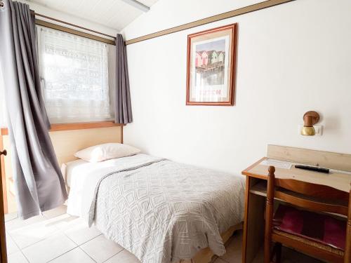 une chambre avec un lit, un bureau et une fenêtre dans l'établissement Hôtel L'Hermitage, à Saint-Georges-dʼOléron