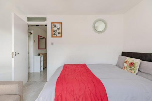 um quarto com uma cama com um cobertor vermelho em London Home With A Beautiful View em Upper Norwood