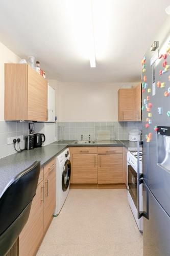 a kitchen with a refrigerator and a washing machine at London Home With A Beautiful View in Upper Norwood