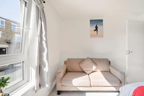 um sofá num quarto com uma janela em London Home With A Beautiful View em Upper Norwood