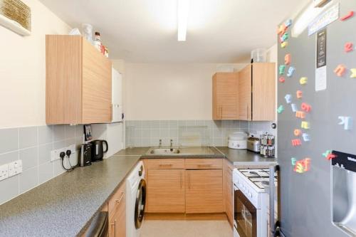 a kitchen with wooden cabinets and a blue refrigerator at London Home With A Beautiful View in Upper Norwood