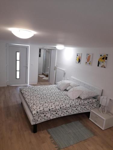um quarto branco com uma cama grande num quarto em Studio Eržen em Zgornje Gorje