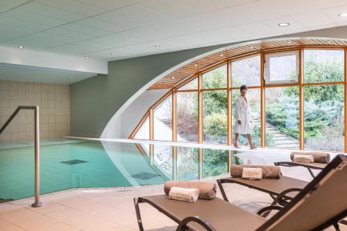 a man standing in a room with a swimming pool at Residence RADIANA in La Léchère