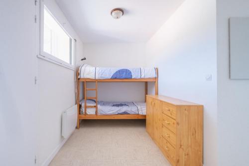 ein kleines Schlafzimmer mit einem Etagenbett und einem Fenster in der Unterkunft L'Océanide - Vue mer pour 6 voyageurs in Saint-Michel-Chef-Chef